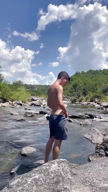 Hung twink gets naked and stroke his cock outdoor beside the river