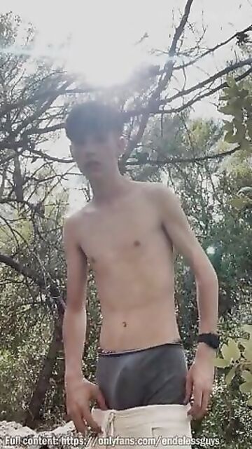 Twink jerks off in the woods against a tree